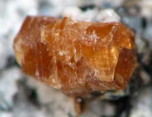 FIGURE 7.21 Synchysite-(Ce), CaCe(CO3)2F, an orange prismatic, pseudohexagonal (monoclinic) crystal to 2 mm.